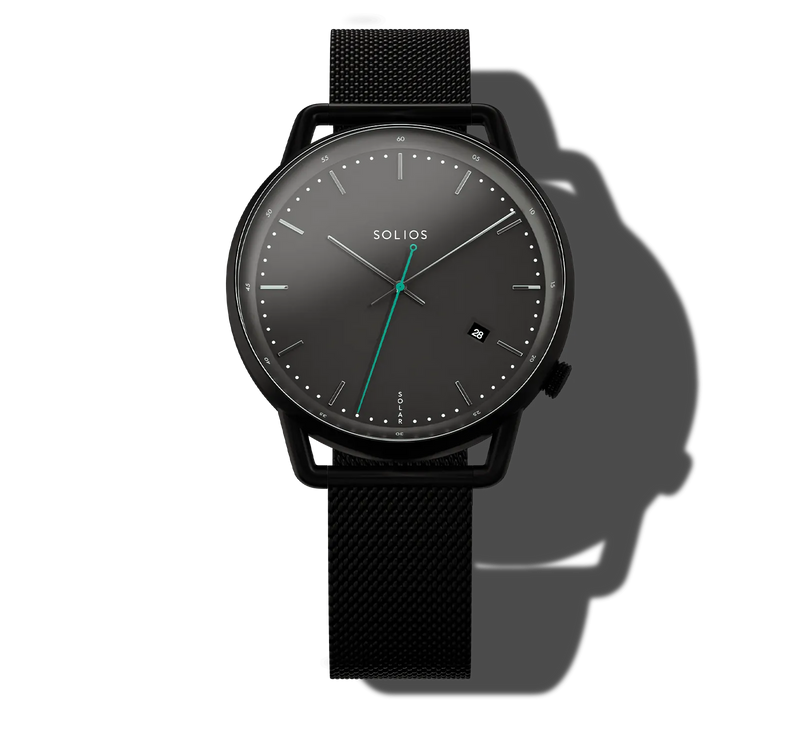 A Solios Curve analog solar watch with a round black dial, minimalist silver-tone hour markers and hands, and a vibrant green center second hand, paired with a black mesh strap. The watch is presented on a clean white background with a dramatic shadow cast to the right.