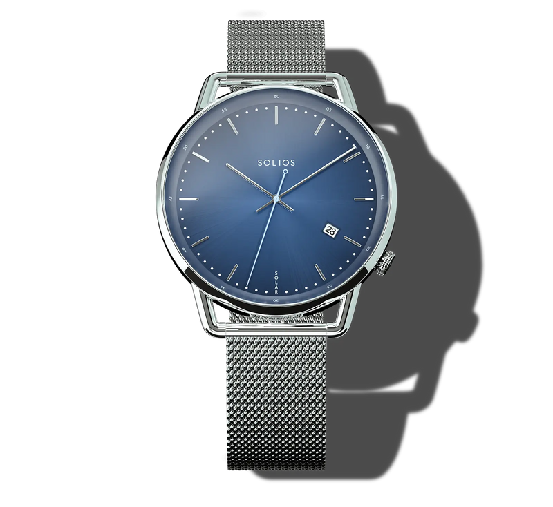 A Solios Curve analog watch with a blue dial, silver hands and markers, and a silver mesh metal strap, shown on a white background with a soft shadow.