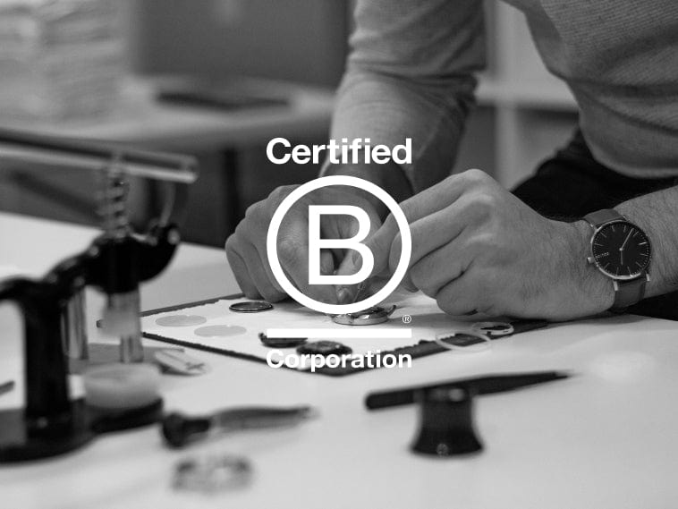 Watchmaker assembling a Solios by hand, with the Certified B Corporation logo.